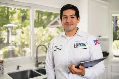 Closeup of Benjamin Franklin Plumbing Tech, Diego, standing in a kitchen of a Orlando FL home