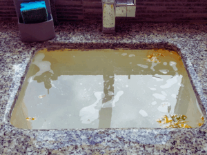 kitchen sink filled up with dirty water because of slow drain