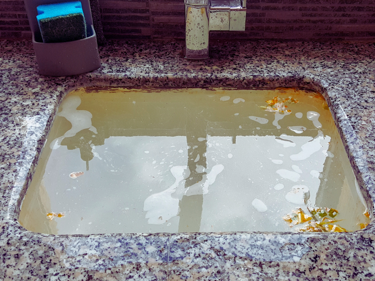 kitchen sink filled up with dirty water because of slow drain 
