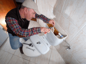 Professional plumber repairing damaged toilet flapper